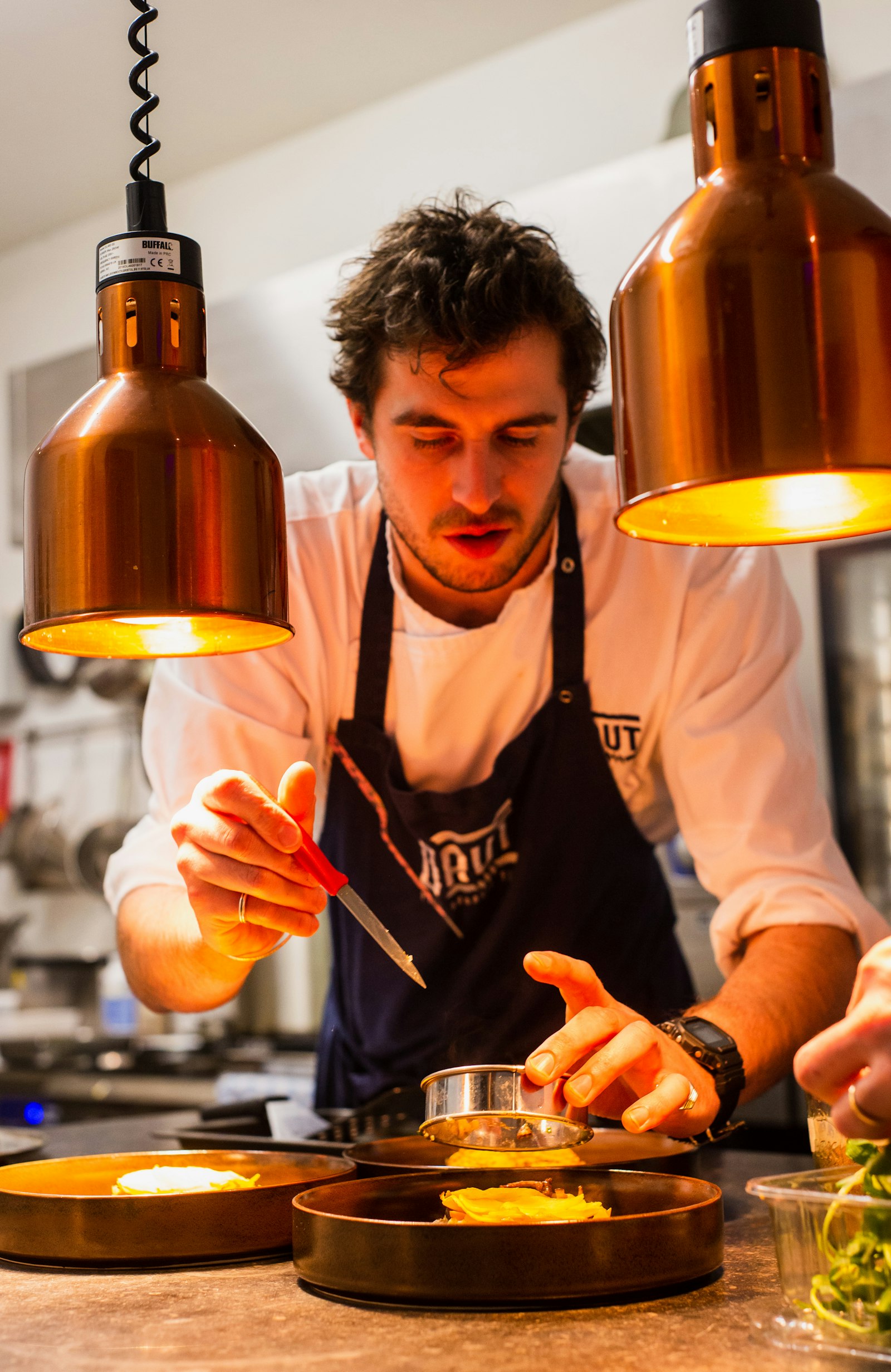 Juan Pablo Restrepo — chef and founder of CRUDO, photographed beside the fire