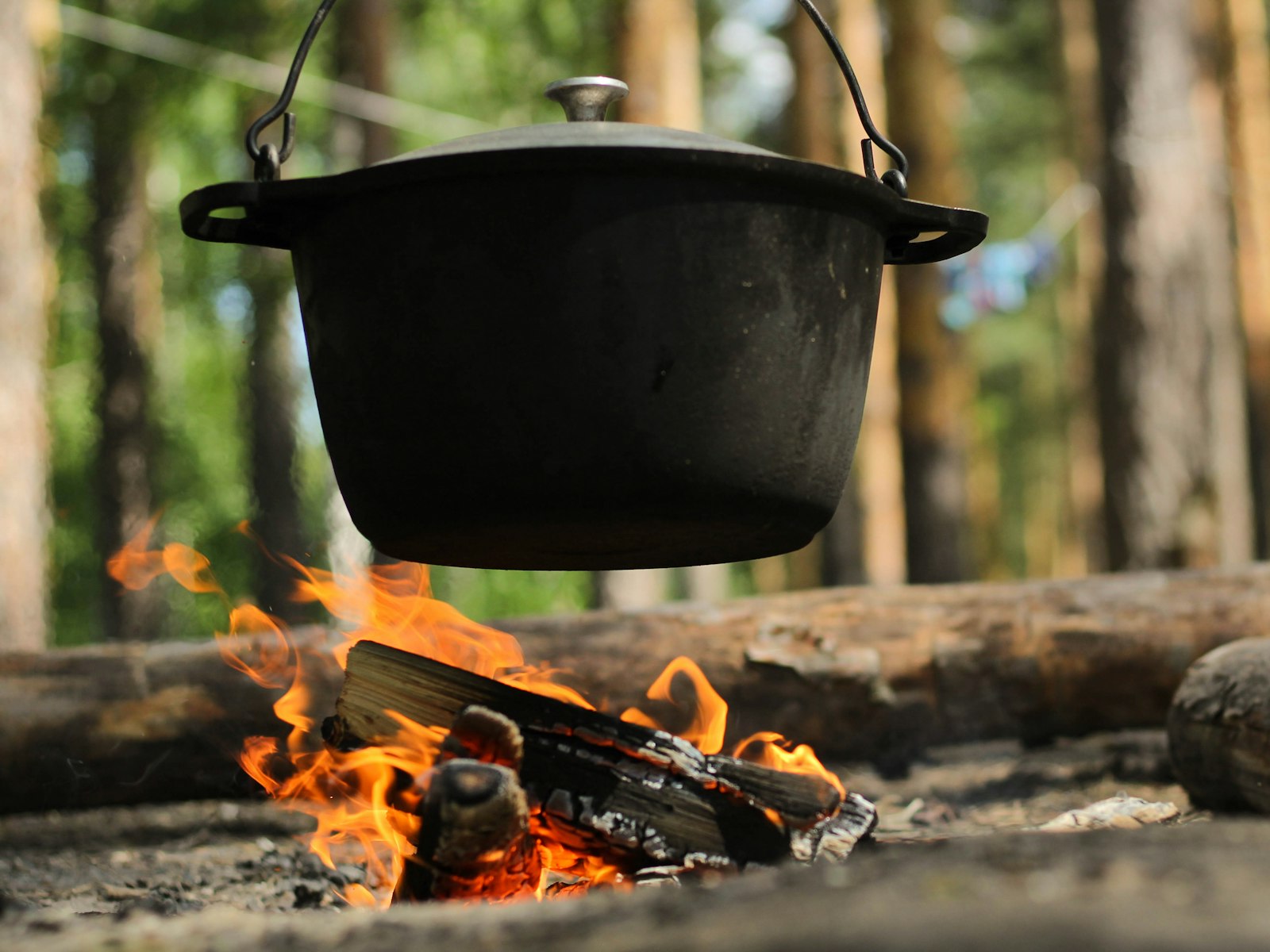 Earthenware pot over an open fire — slow-cooked seasonal CRUDO dish